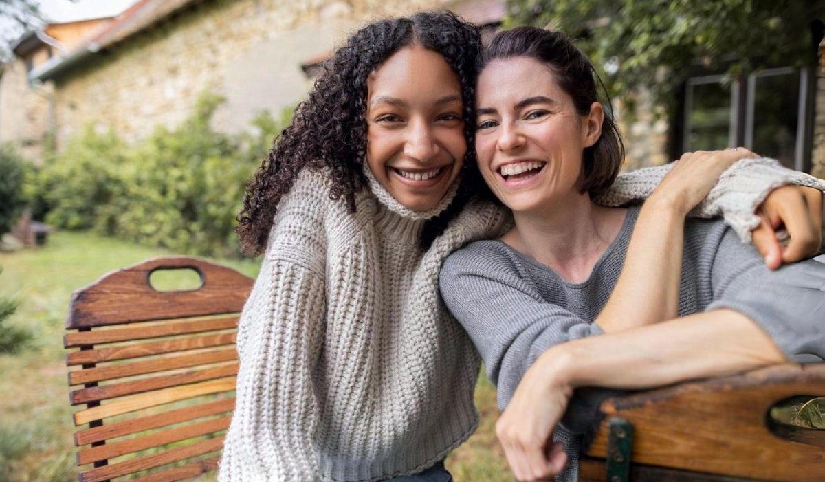 Smiling friends sitting together outdoors